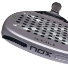 Bovenaanzicht afneembare gewichten Nox Attack 18k 2027 grijs padel racket met lichter grijs X logo op het slagoppervlak.