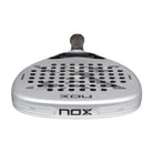 Bovenaanzicht Nox Attack 12k 2027 licht grijs padel racket met donkerder grijze x op het slagoppervlak.