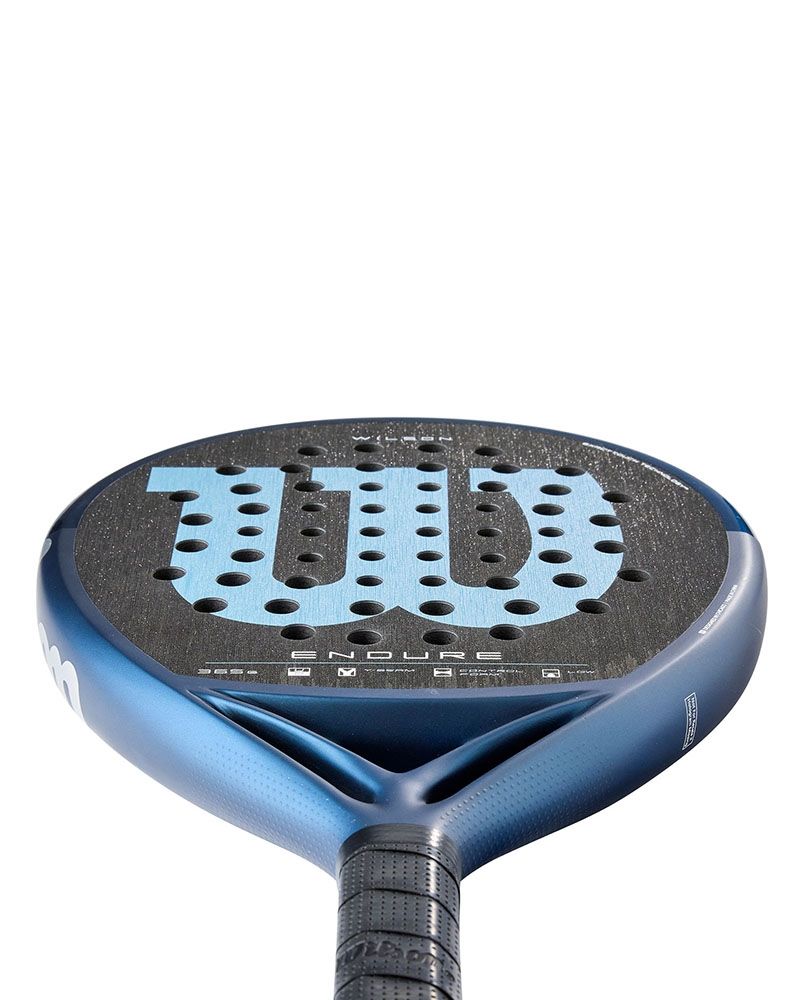 Detail slagoppervlak Wilson Endure V1: rond controle-padelracket met lage balans, Y-Bridge design en hybride slagvlak. Donkerblauw kader met lichtblauw Wilson logo.
